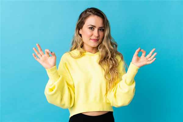 Девушка мило улыбается и показывает ок