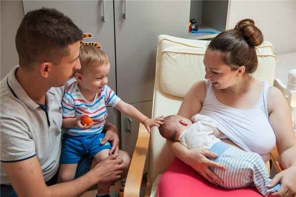  Мать кормит своего ребенка грудью, а отец и старший сын поддерживают их