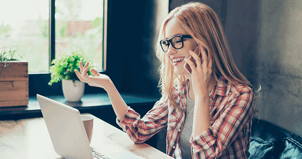 Девушка в очках говорит в очках по телефону