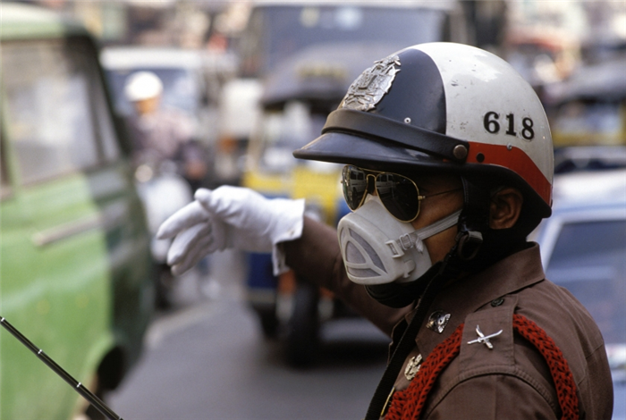 A police officer directs traffic while wearing a mask