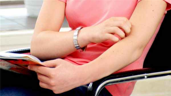 Девушка чешет руку