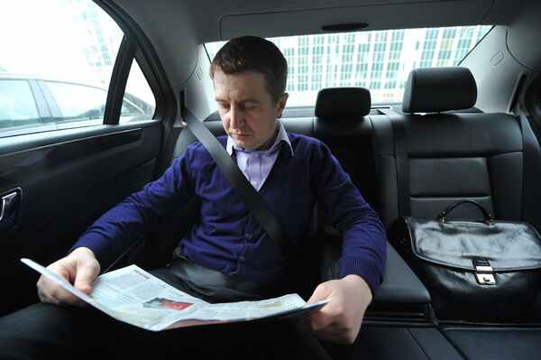 Мужчина читает газету в такси