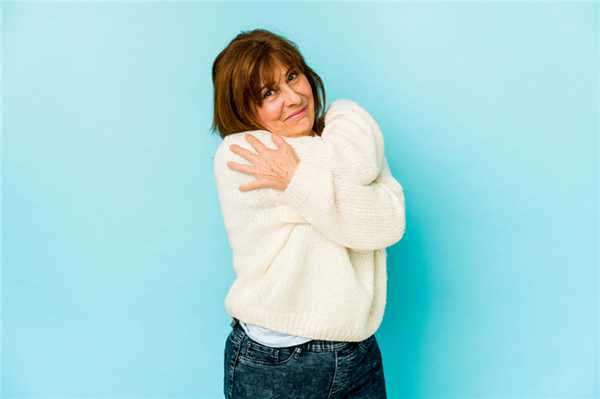 пожилая женщина обнимает себя