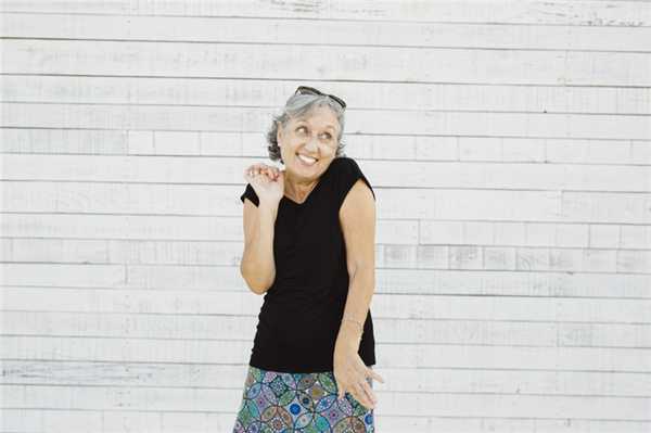 Старшая женщина делает гримасу над белой поверхностью