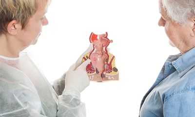 Врач колопроктолог показывает макет прямого канала и рассказывает о заболеваниях ректум