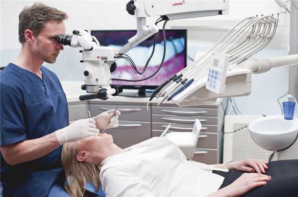 Установка зубной коронки под микроскопом