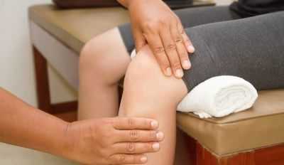 Врач осматривает колено