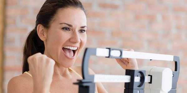 Девушка взвешивается на весах