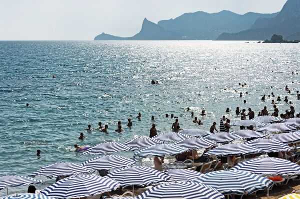 Отдыхающие на берегу Черного моря в Судаке