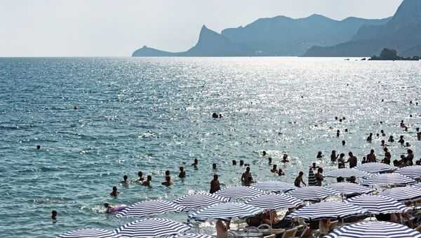 Отдыхающие на берегу Черного моря в Судаке