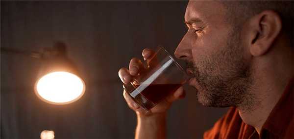 мужчина пьет алкоголь из стакана