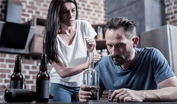 мужчина смотрит на бутылку алкоголя