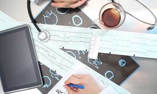 На столе ЭКГ и снимки КТ