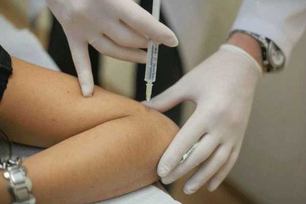 Доктор делает укол в локоть