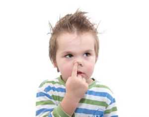 ребенок ковыряет в носу и смотрит с сторону