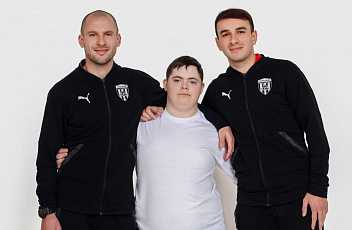 Молодая женщина-врач с синдромом дауна, проверяя ее пульс над белой стеной.