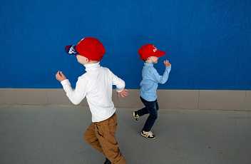 Молодая женщина в зеленой форме стоя и позирует.