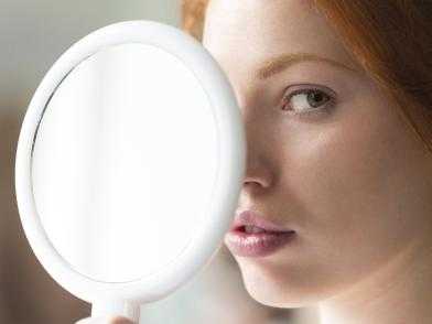 девушка смотрит в увеличительное зеркало