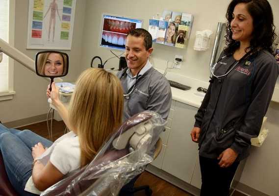 Врач с пациентом после установки виниров