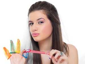 Девушка играет с презервативами